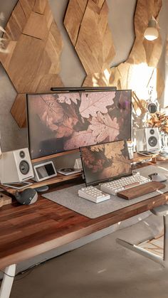 a wooden desk with a computer and speakers on it, in front of wood wall art