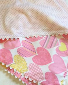 pink and yellow hearts on white bedding with polka doted pillowcase, ruffled edge