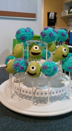 there are some cake pops with green and blue frosting on them in the shape of monsters