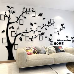 a living room with a couch and tree on the wall