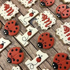 decorated cookies with ladybugs and the letter i on them are laid out on a wooden table