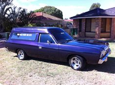 a purple station wagon parked in front of a house