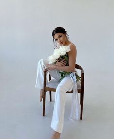 a woman sitting in a chair holding a bouquet of flowers