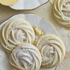 some sugar cookies are on a plate and one is covered in powdered sugar,