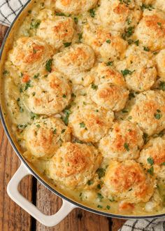 a casserole dish with meatballs and cheese in it on a wooden table