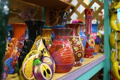 many different colored vases are sitting on a shelf