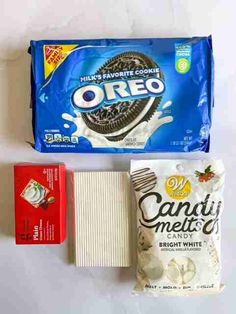 an oreo cookie, candy bar, and other snacks are laid out on a white surface