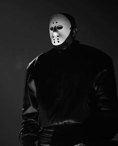 a man wearing a mask standing in the dark