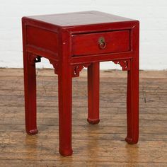 a small red wooden table with one drawer