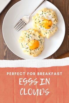 an egg in the middle of two biscuits on a plate with a fork and napkin next to it