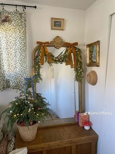 a mirror sitting on top of a wooden dresser next to a plant in a pot