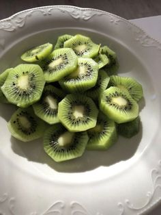 sliced kiwis in a white bowl on a table