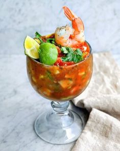 a glass filled with food and garnished with lime