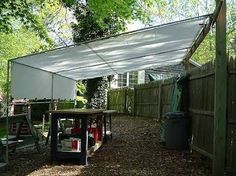 an outdoor area with tables, chairs and a canopy over the back yard is covered by white tarps