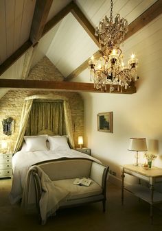 a bedroom with a chandelier hanging from the ceiling and a bed in it