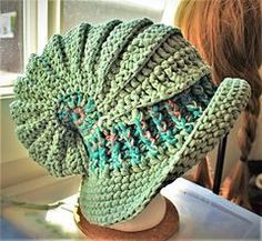 a green hat sitting on top of a table next to a woman's head