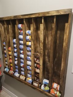 an old wooden pallet filled with canned food and cans on the wall next to a light switch