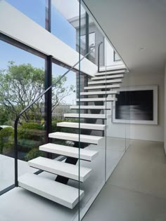 there is a white staircase with glass railings on the outside and in the inside