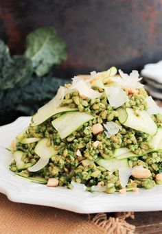 a white plate topped with cucumber and other food on top of a table