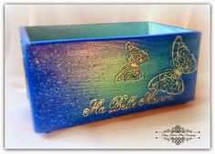 a blue box with two butterflies on the side and words written in gold foiling