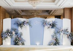 an image of a stage set up for a wedding ceremony with flowers on the wall