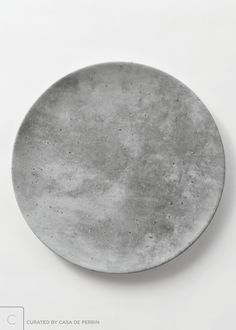 a white plate sitting on top of a table next to a black and white wall