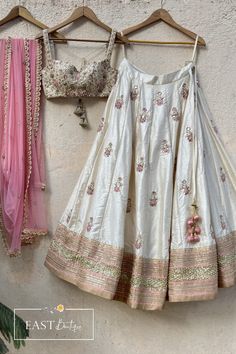 This beautiful off-white raw silk lehenga with colourful sequins, stone and zardozi hand embroidery is paired with a bustier in raw silk with mirror and thread zardozi work all over. This outfit is completed with a pink net dupatta with scallop edging with highlights. Lehenga With Mirror Work, Simple Lehenga, Raw Silk Lehenga, Trendy Outfits Indian, Zardozi Work, Indian Outfits Lehenga, Lehenga Designs Simple, Traditional Indian Dress, Desi Fashion Casual