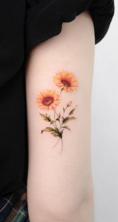 a sunflower tattoo on the left upper arm and lower arm, with two flowers in it