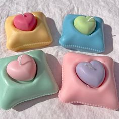 four small heart shaped soaps sitting on top of a white cloth covered tablecloth