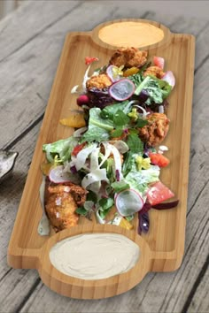 a wooden platter filled with salad and dressing