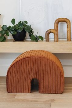 a wooden sculpture sitting on top of a table next to a potted plant