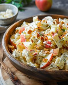 a wooden bowl filled with potato salad on top of a table