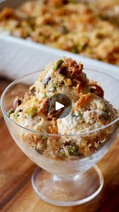 a glass bowl filled with food on top of a wooden table