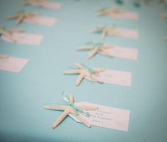 small starfishs are placed on the table for guests to sign in their place cards