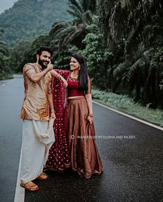 a man and woman standing on the side of a road in front of palm trees