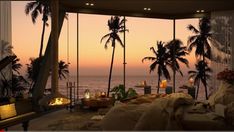 a bed sitting under palm trees in front of a fire place with candles on it