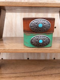 Turquoise Centered Concho On Handpainted Leather Bracelet The turquoise centered concho on handpainted leather bracelet is one of our store's best sellers. Featured with a silver concho with a turquoise in the center, this bracelet is going to stand out on your wrist! Perfect to match with your western boho vibe outfit. Measurements: 1" width Closure: Snap Color: Turquoise Western Boutique, Hand Painted Leather, Color Turquoise, Western Boho, Cool Store, Boho Vibe, Turquoise Jewelry, Best Sellers, Leather Bracelet