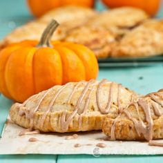 two pumpkin pies sitting on top of a blue table