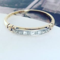 a gold and white diamond wedding ring sitting on top of a table