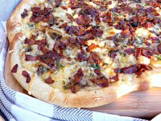 a pizza sitting on top of a wooden cutting board