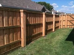 a wooden fence in the backyard with grass