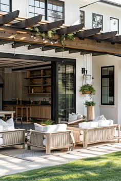 an outdoor living area with wicker furniture and wooden pergolated trelliss