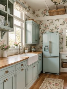 a kitchen with blue cabinets and floral wallpaper