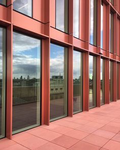 an orange building with many windows reflecting the sky