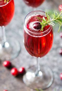 two glasses filled with cranberry wine and garnished with rosemary