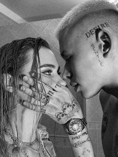 a man and woman with tattoos on their faces are kissing in front of each other