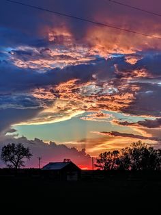 the sun is setting behind some clouds in the sky