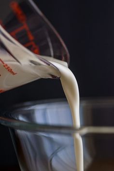 milk being poured into a glass bowl