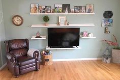 a living room filled with furniture and a flat screen tv mounted on a wall above a wooden floor