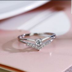 a diamond ring sitting on top of a pink table